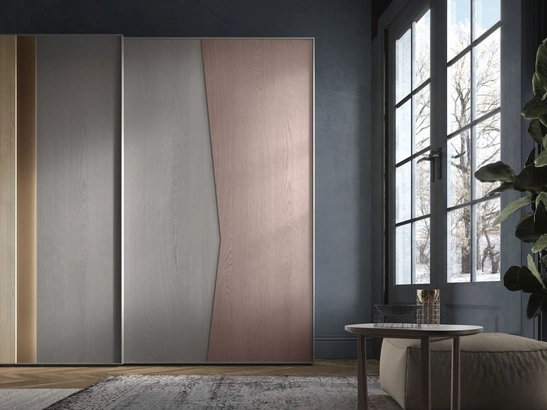 Armadio con ante scorrevoli in frassino tinto con colori differenti e inserti in legno cannettato e in laccato Rame Ring di Adriatica